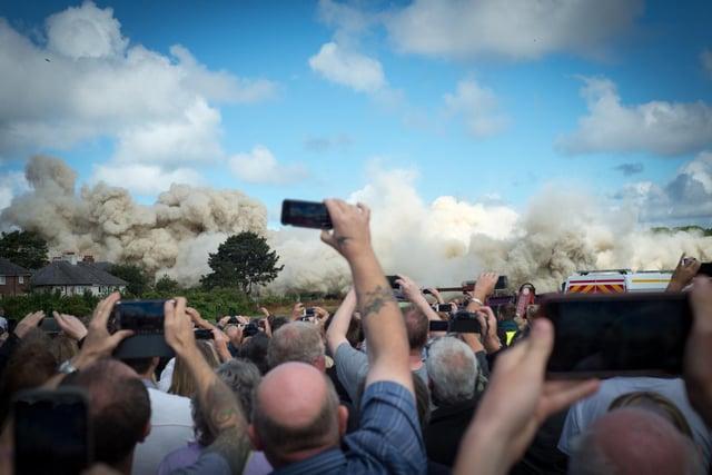 Mobile phones were out as people captured the moment the flats tumbled to the ground Photo: Melanie Whiteside