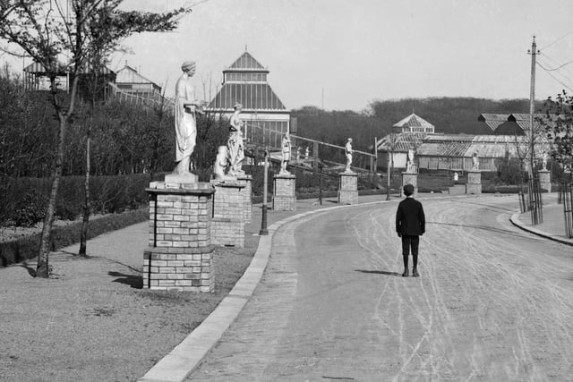 Looking along the statue lined main drive of Raikes Hall Gardens in the 1890s. In the trees on the left is the switchback railway, beyond it is the Monkey House and in the distance on the right is the annular conservatory surrounding the skating rink