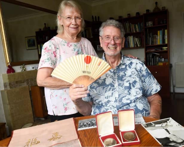 Brian Dickinson pictured with wife Val and fencing medals/memorabilia ahead of the Tokyo Paralympics last year