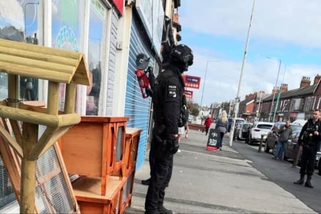 Police use a circular saw to cut through the shutters and gain entry to Bud Lovers Bargains in Poulton Road, Fleetwood