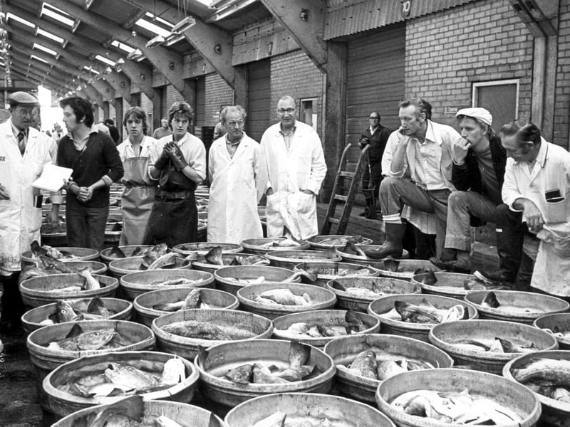 Fish merchants gather round for the last auction of fish caught by middle-water vessels at the port