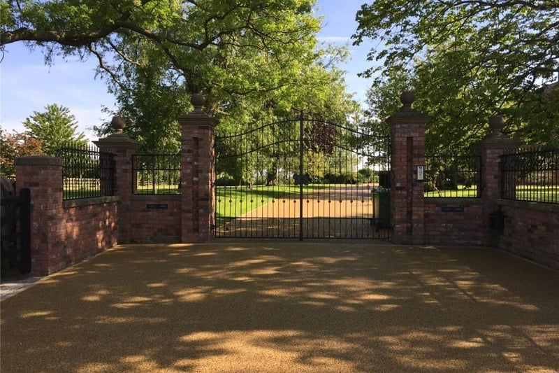 The house is behind double gates at the end of a sweeping driving