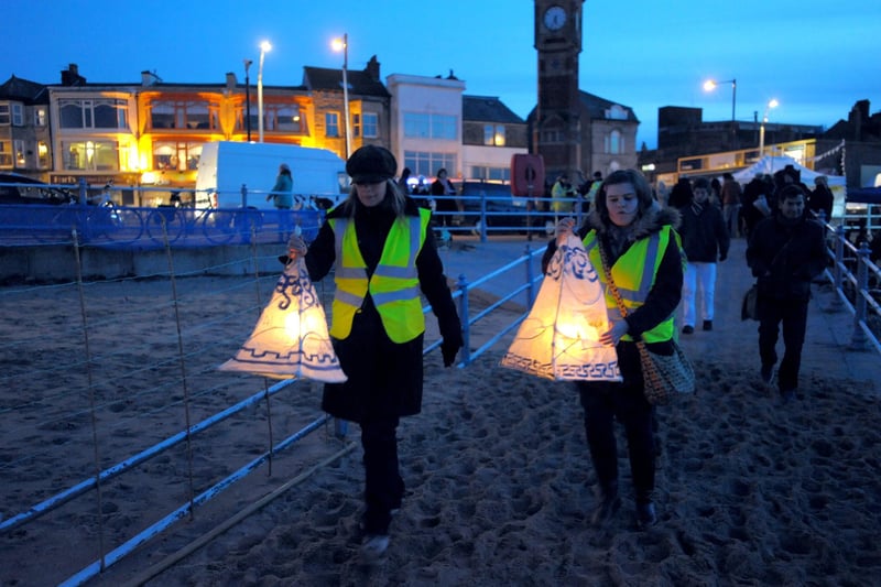 Lanterns are carried onto the beach near the Clock Tower in Morecambe for the Sigh of the Sea event to mark the 10th anniversary of the cockling tragedy.
