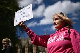 A disability campaigner from "Dignity in Dying" holds a placard as she demonstrates outside  Westminster (Pic: Ben Stansall/AFP via Getty Images)