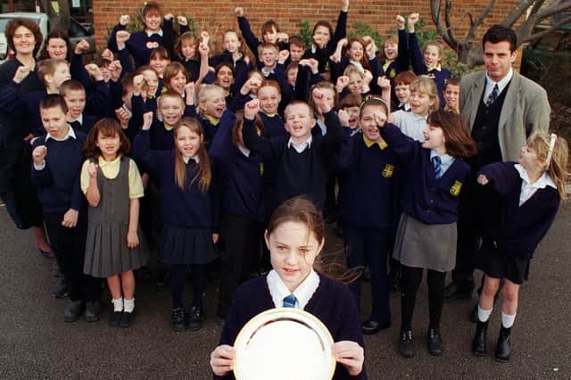 Children and teachers at Mereside School with a silver plate awarded for service to the community. Hanna Ratcliffe 8 is pictured front