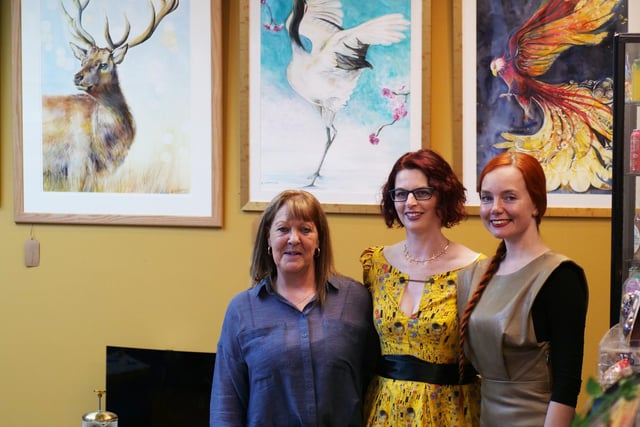 Janey Campbell, Emma Underwood (artist), and Anna Paprzycka, (Tea Amantes owner) pose for a photo in front of some paintings.