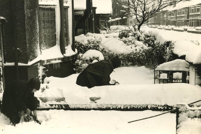 The scene in a Blackpool street following a heavy fall of snow in 1940. Clearing the snow was everyone's job before they could get out.