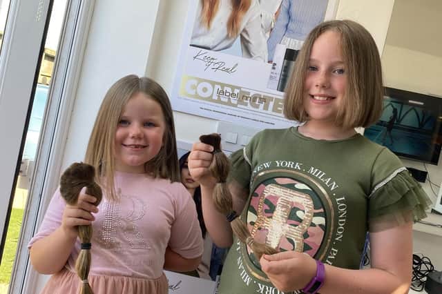 Charlotte (left) and Evie Abberley had their hair cut - and helped two good causes