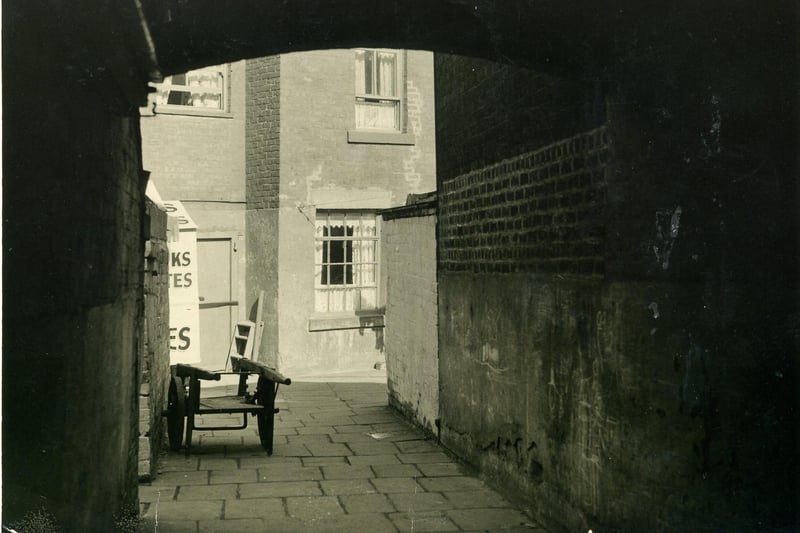 Pleasant View seen here through an archway from Bonny Street. A cockle sellers mobile stall can just be seen to the left of the arch