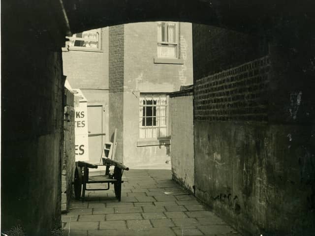 Pleasant View seen here through an archway from Bonny Street. A cockle sellers mobile stall can just be seen to the left of the arch