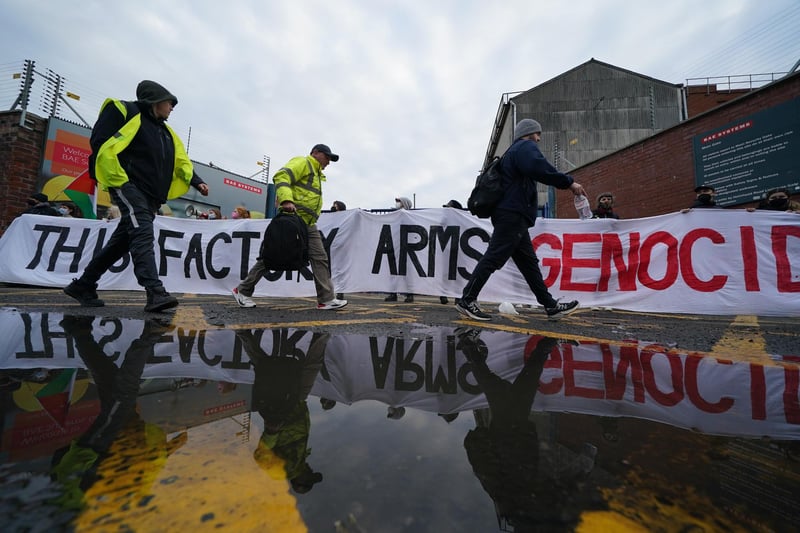 People walk past protesters forming a blockade outside weapons manufacturer BAE Systems in Govan, Glasgow, in protest over the Israel-Gaza conflict and calling for an immediate ceasefire to halt the killing of civilians in Palestine.