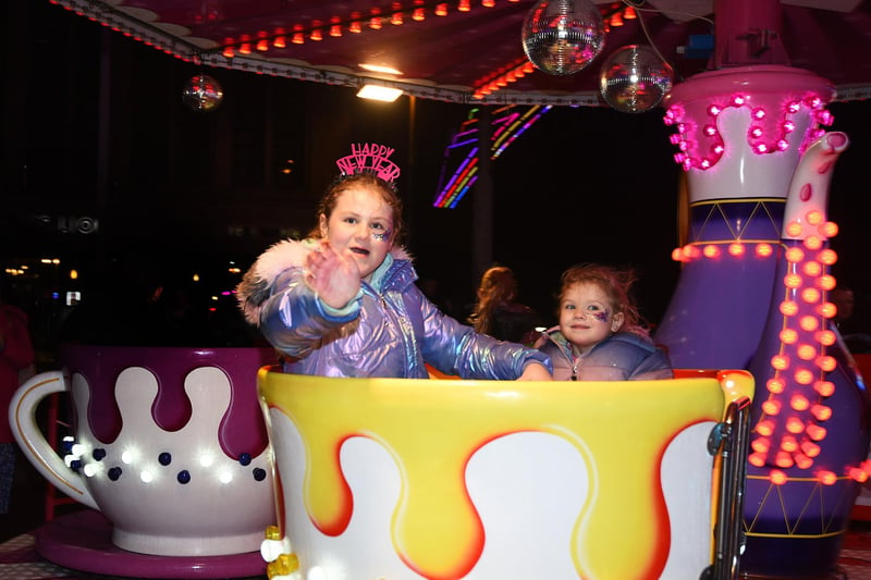 Phoebe Williams and sister Korla have fun on the popular spinning cup ride during the the Carpet family party on Blackpool's Comedy Carpet