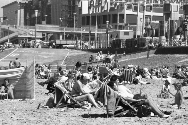 It must have been a miserable summer because the caption on the back of this photo reads: 'Shock appearance of the sun sent youngsters of all ages on to the beach at Blackpool, scratching their heads and trying to remember how to tackle a real summer. Swim suits came out, buckets and spades were dusted down and, for the first time this year, sandcastles proliferated along the shore, with the occasional father buried beneath them'