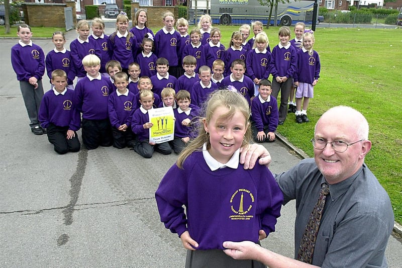 Youngsters from Boundary Primary School were en route to the Commonwealth Games to sing at the welcome ceremony in 2002. Head Teacher Stephen Twist highlights the motif on the commemorative top worn by Mercedes Lyons