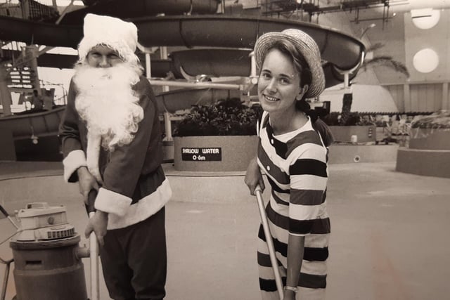 Santa lends a helping hand at the Sandcastle in December 1989 to clean the pool floor. With him is Angela Pinder