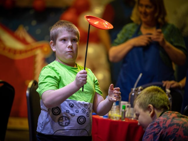 This young man practises the skills of plate-spinning at the young carers' party at Blackpool Tower