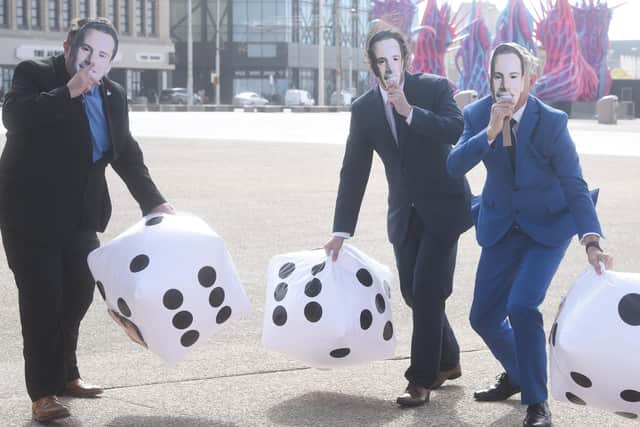 Labour Party members don Scott Benton masks on the Comedy Carpet in Blackpool