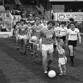 Keith Mercer looking happy enough as he led out Blackpool for his Bloomfield Road swansong. But four-year old son Nathan proved a reluctant mascot