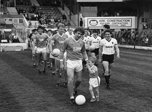 Keith Mercer looking happy enough as he led out Blackpool for his Bloomfield Road swansong. But four-year old son Nathan proved a reluctant mascot