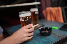 A person smoking a cigarette outdoors in a pub. PIC: Yui Mok/PA Wire