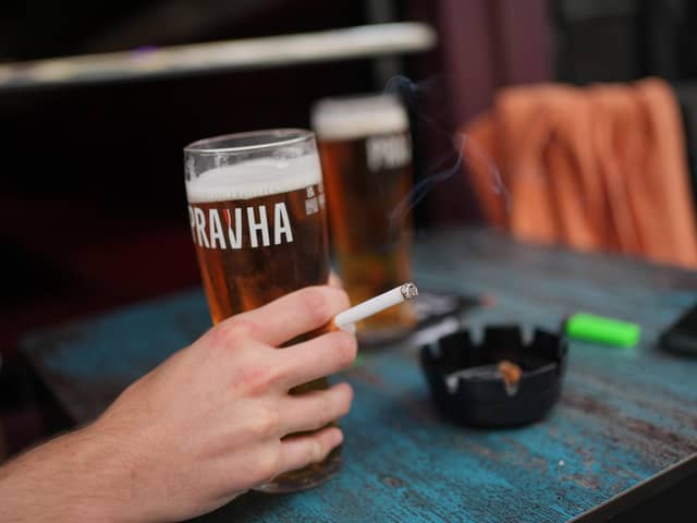 A person smoking a cigarette outdoors in a pub. PIC: Yui Mok/PA Wire