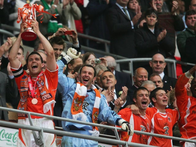 The Blackpool squad lift the trophy.