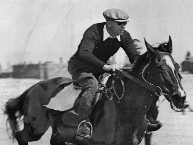 A galloping George Formby on the beach in 1950