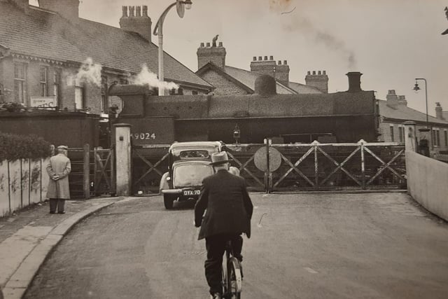 Not a sight you will see anymore - gates are down at the level crossing in Thornton as a steam train makes its entrance in 1929