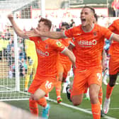 Jerry Yates celebrates with the Blackpool fans after drawing Michael Appleton's side level