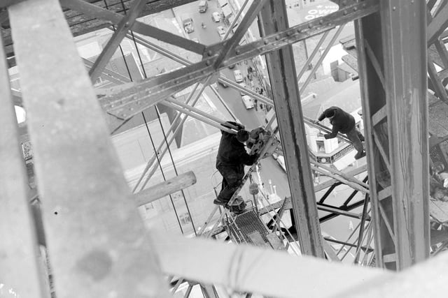 Workmen busy painting Blackpool Tower, they are seen here on the rods between the huge girders in August 1958