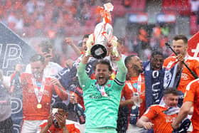 LONDON, ENGLAND - MAY 30: Chris Maxwell of Blackpool lifts the Sky Bet League One Play-off Trophy as his team mates celebrate following victory in the Sky Bet League One Play-off Final match between Blackpool and Lincoln City at Wembley Stadium on May 30, 2021 in London, England. (Photo by Catherine Ivill/Getty Images)