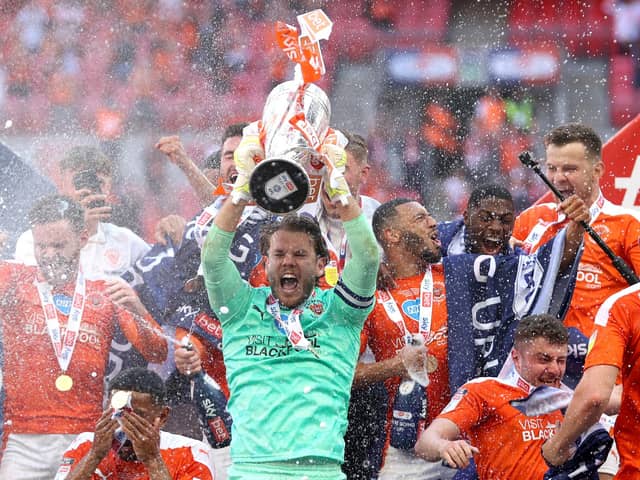 LONDON, ENGLAND - MAY 30: Chris Maxwell of Blackpool lifts the Sky Bet League One Play-off Trophy as his team mates celebrate following victory in the Sky Bet League One Play-off Final match between Blackpool and Lincoln City at Wembley Stadium on May 30, 2021 in London, England. (Photo by Catherine Ivill/Getty Images)