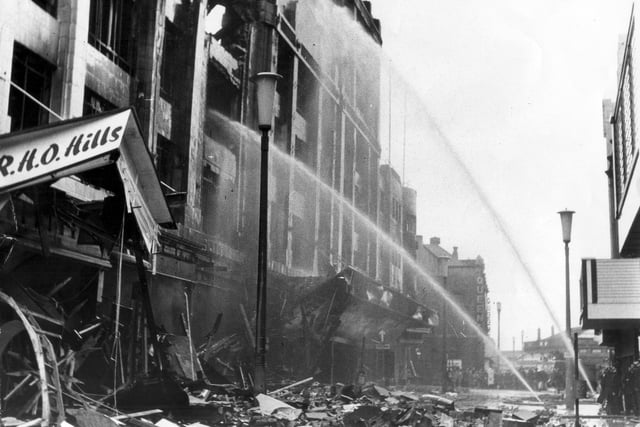 In scenes like the wartime blitz dawn found RHO Hills in Bank Hey Street a smoking wreck. "Dawn and still thousands of gallons of water are poured into the smoking debris"