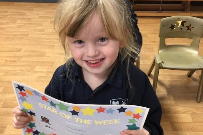 My little granddaughter with her star of the week certificate