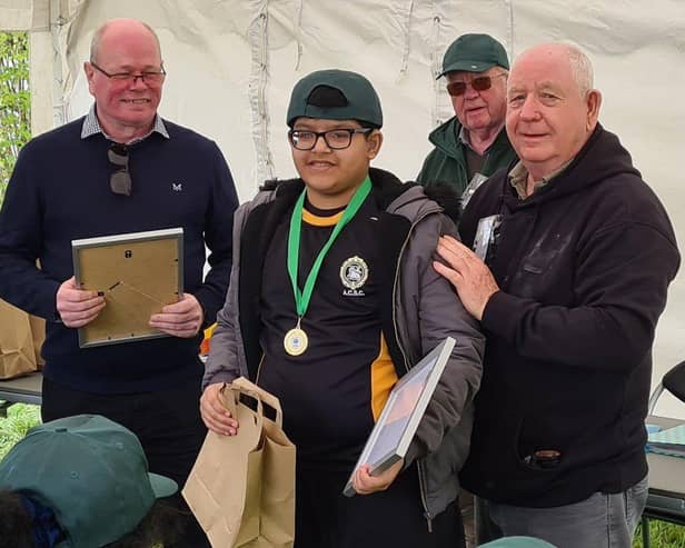 Qais being presented with his Fishing Achievement Medal by Duncan Smith and Harry Cox