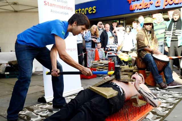 Street performer lays on a bed of nails to raise money for Doncaster Stammering Association.