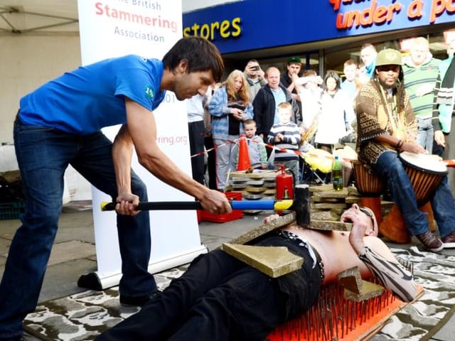 Street performer lays on a bed of nails to raise money for Doncaster Stammering Association.