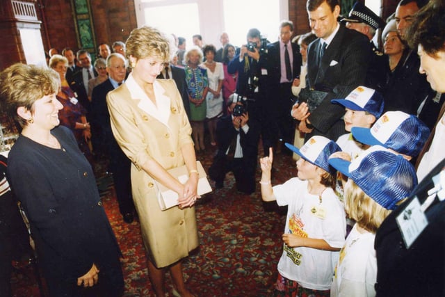 Princess Diana looks on attentively at a youngster uses sign language at Blackpool Tower World in 1992
