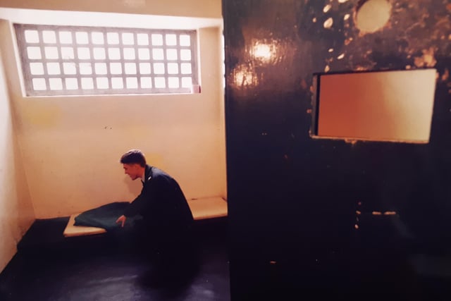 PC Scott Sanders lays out a blanket in a police cell