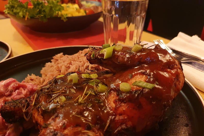 Traditional Caribbean jerk half-chicken with rice and peas