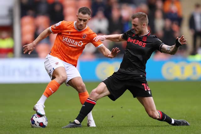 BLACKPOOL, ENGLAND - FEBRUARY 18: Jerry Yates of Blackpool is challenged by Ben Wilmot of Stoke City during the Sky Bet Championship between Blackpool and Stoke City at Bloomfield Road on February 18, 2023 in Blackpool, England. (Photo by Charlotte Tattersall/Getty Images)