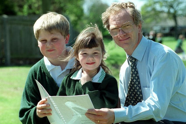Carleton CE Primary School headteacher Michael Tempan is pictured looking at the report with the youngest girl in the school - four year old Victoria Sanderson and  11 year old Carl Berrisford