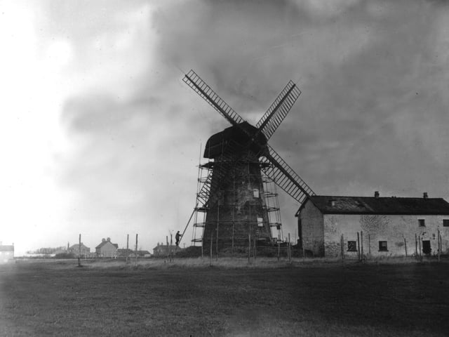 Little Marton Windmill and malthouse or miller's house in Preston New Road. The photo shows the windmill undergoing renovation prior to the demolition of the house in 1957. In the distance from the left can be seen properties on the edge of the Mereside Estate, The Clifton Arms (with it's tall chimney) with St Monica's church hall in front of it. Also seen are The Smithy Garage , and Braithwaite Manor (at the junction with Mythop Road)