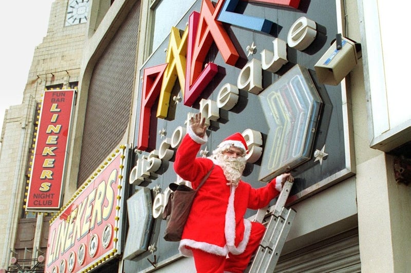 Father Christmas climbs a ladder to check the illuminated sign at the Palace Nightclub - to launch "Keep Santa Safe"