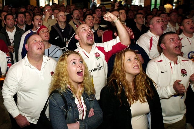 Excited England fans watch England against Australia in a rugby final at Walkabout, 2003