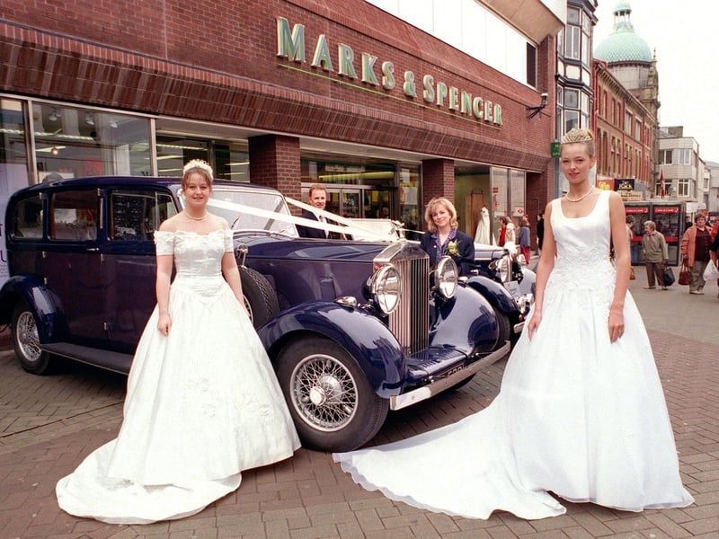 This was a Wedding Event at Marks & Spencer in 1998. Pictured in dresses from Bridal Cottage (Fleetwood) are Sarah Davis (left) and Lynette Marsden, with M&S Wedding List Advisor Julie Jackson. The cars were supplied by 'Aristocrats'
