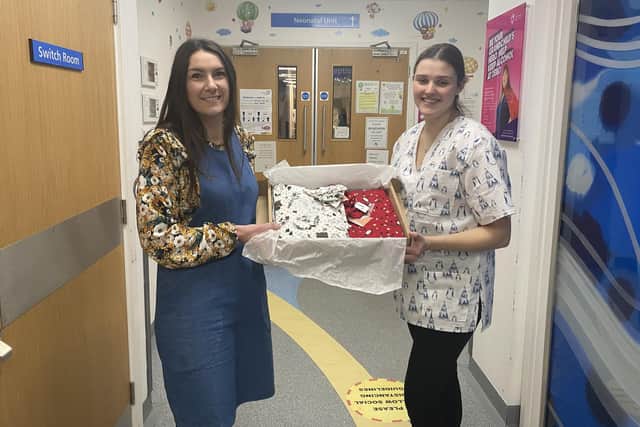 Lucy Plumbley , from The Sewing Institute, handing over the scrubs to Sarah Steward, practice development sister at Blackpool Victoria Hospital's neonatal unit