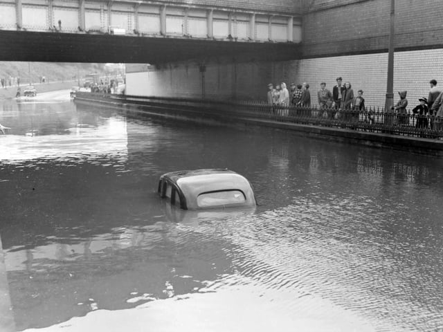 A terrific thunderstorm and downpour of rain caused flooding in several areas of Blackpool in 1958. The depth of the water under the railway bridge at Devonshire Road is indicated by the stranded car