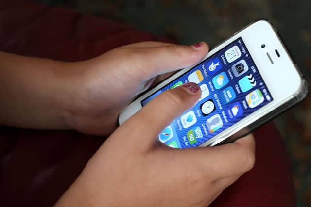 A child using an Apple iPhone smartphone. PIC: Peter Byrne/PA Wire
