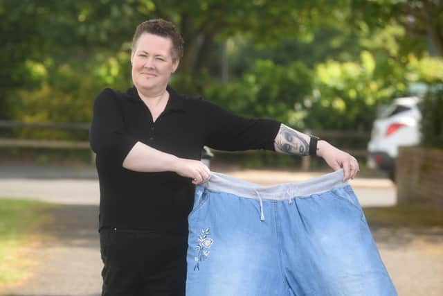 Cat Collins pictured with the jeans she used to wear before she made lifestyle changes and kicked her diabetes into remission